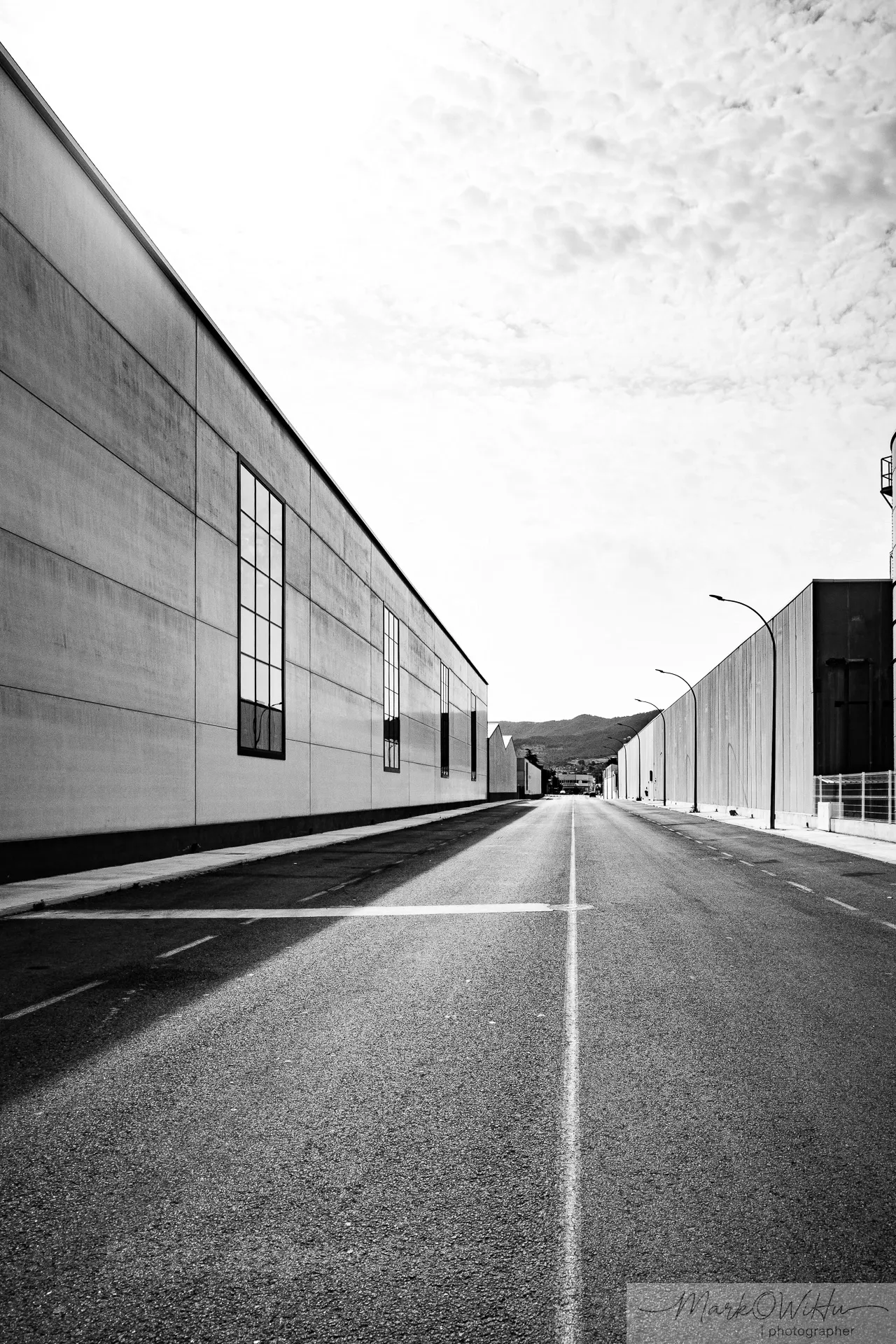 Black and white high-contrast urban street perspective with sharp vanishing lines and geometric buildings