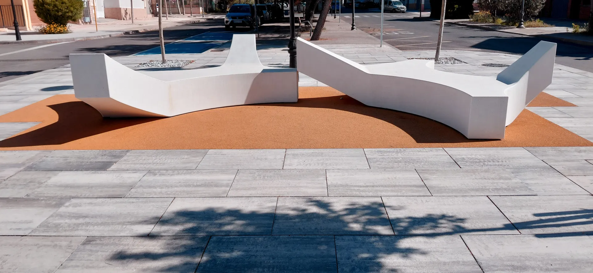 Sculptural white curved bench in a modern urban plaza under sunlight
