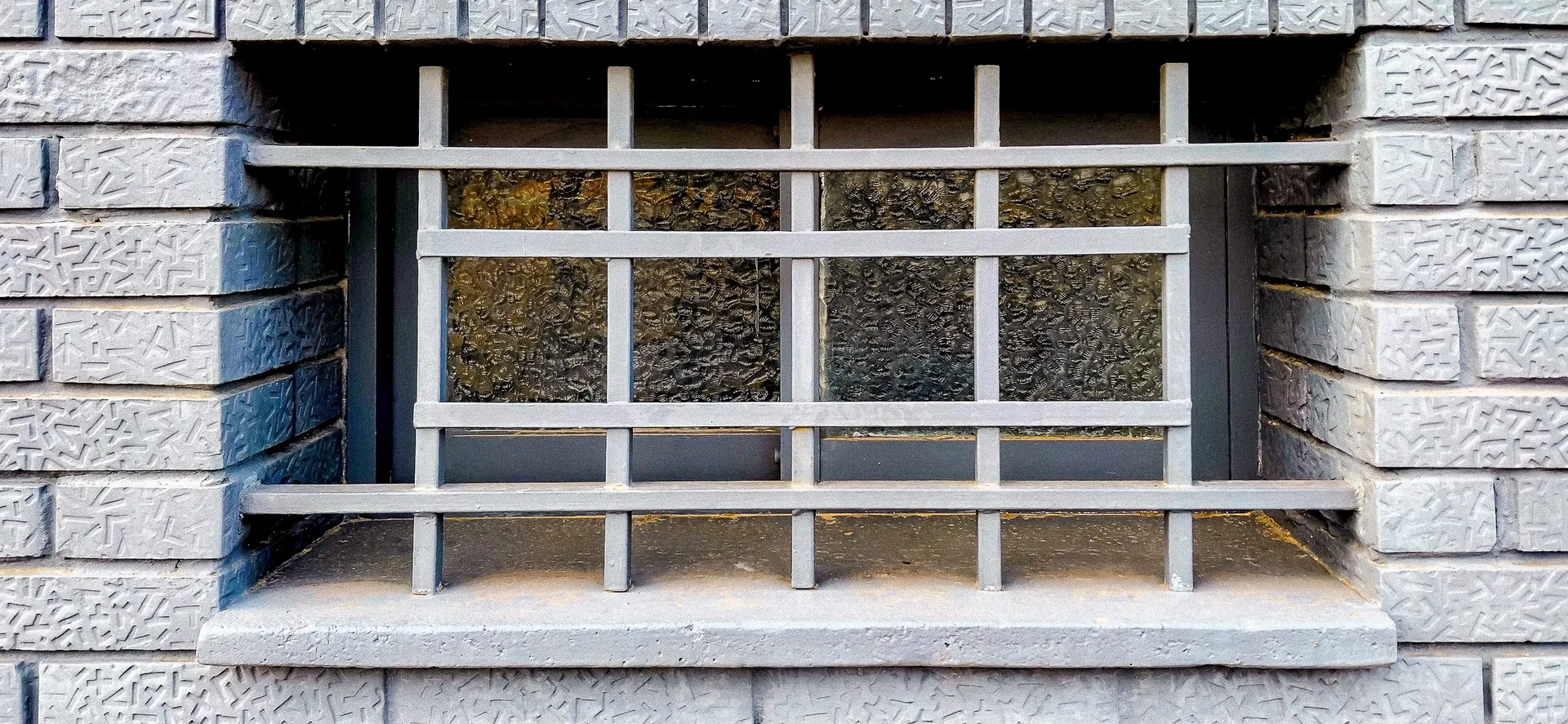 Industrial grid geometry featuring square window bars set in concrete masonry