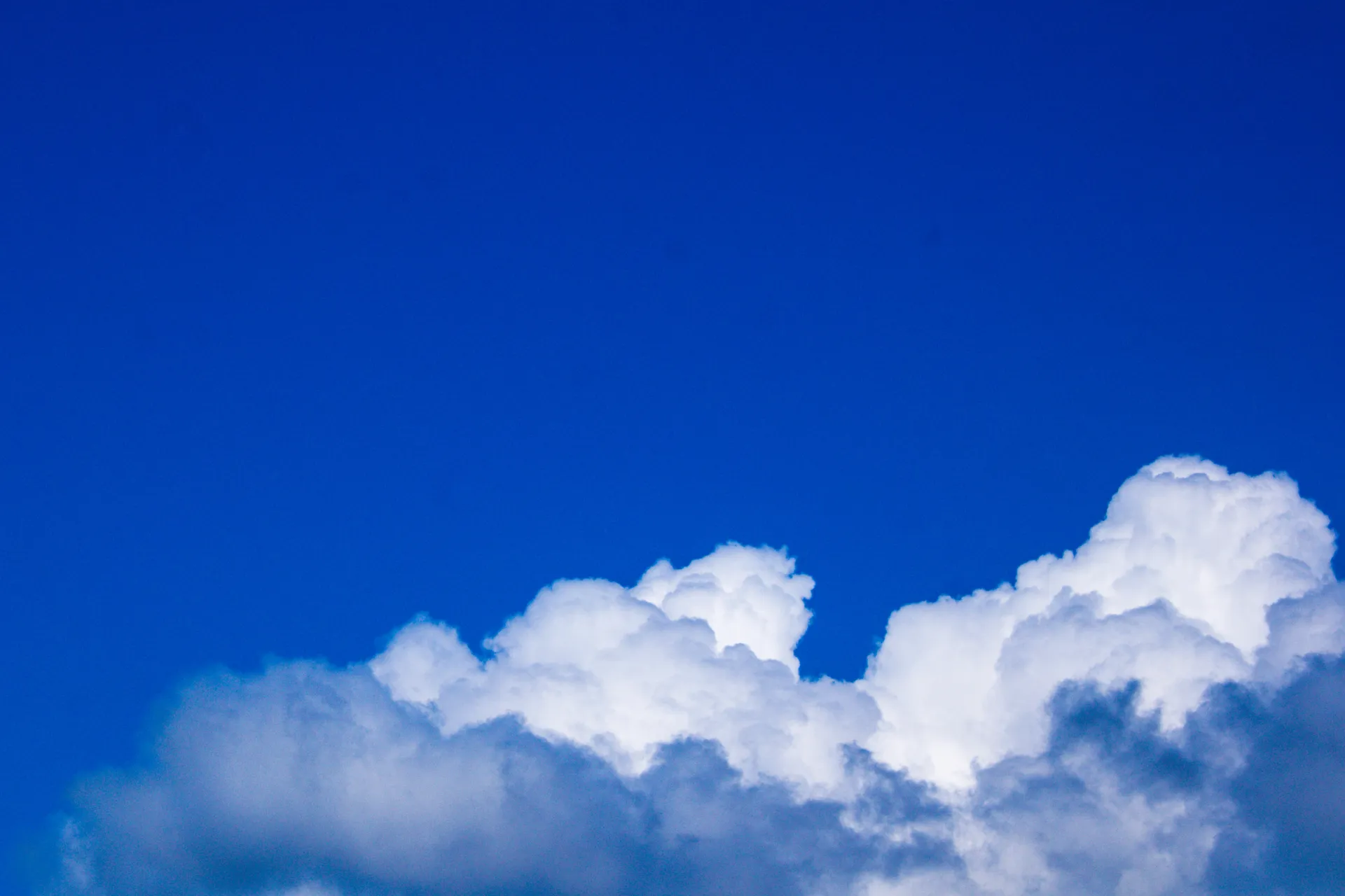 Minimalist cloud formation against deep blue sky