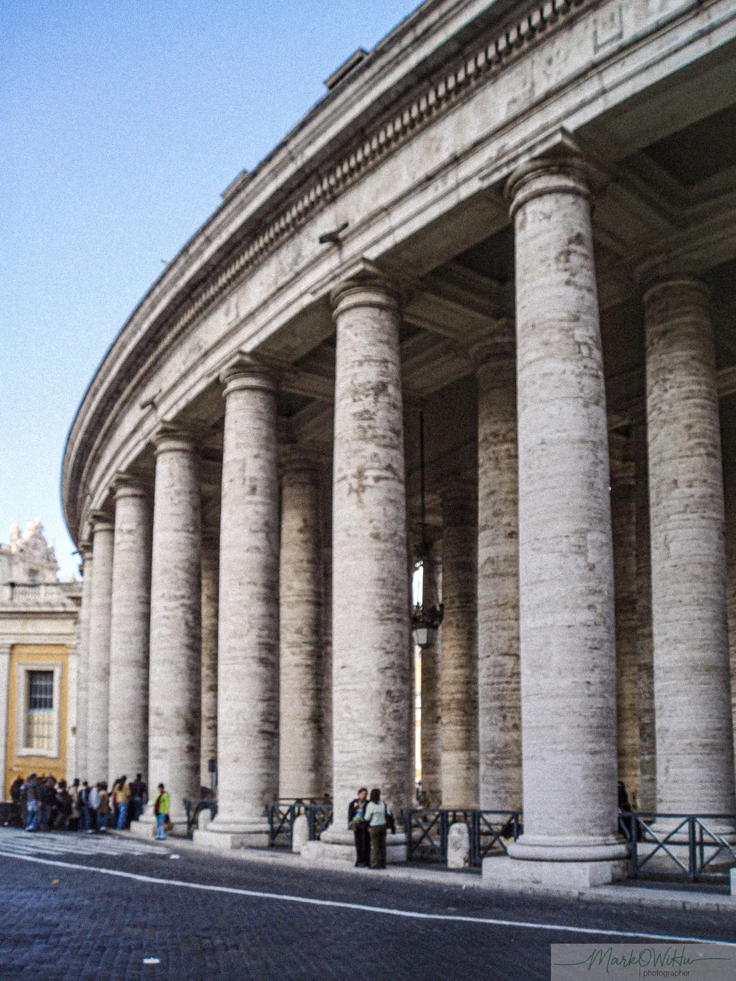 Sweeping perspective of classical Vatican colonnade travertine columns with pedestrians | Street & Humanity | Rome | MarkOWiHu Photographer Fotógrafo • markowihu.es