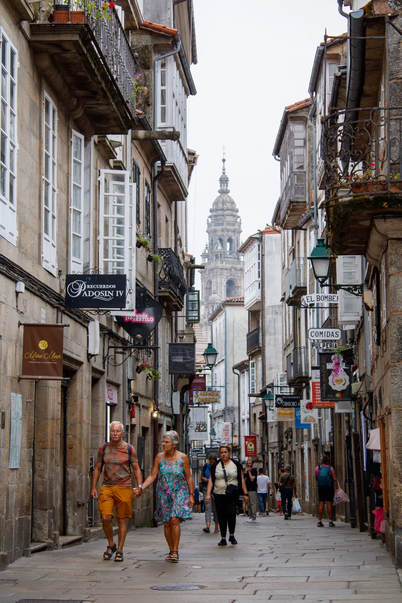Historic narrow Mediterranean alleyway with visitors walking toward distant church tower | Street & Humanity | Alicante province | MarkOWiHu Photographer Fotógrafo • markowihu.es